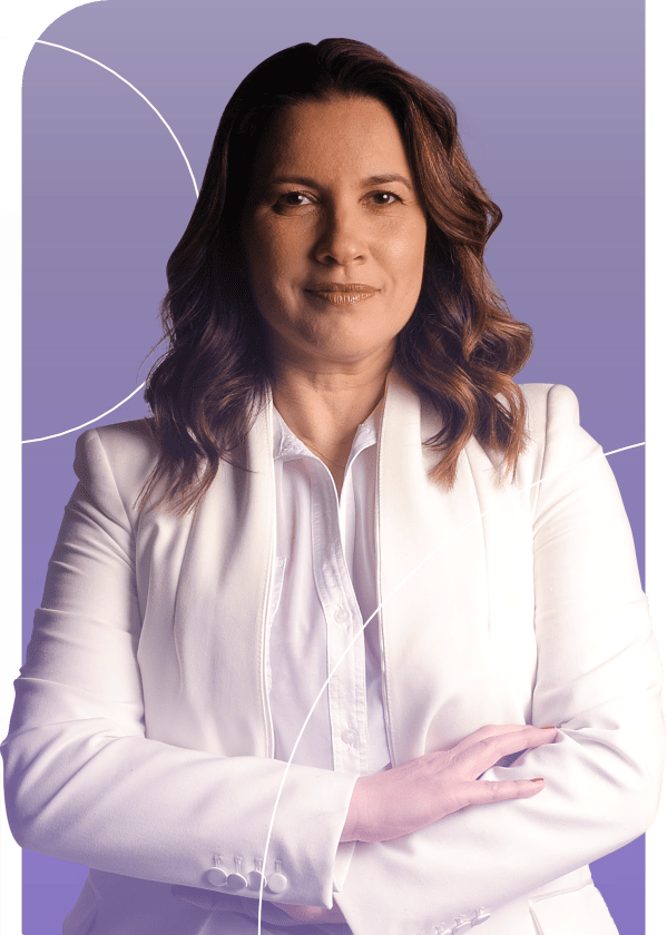 Grupo de pessoas sorrindo em pose para uma foto em conjunto em um prédio com janelas ao fundo